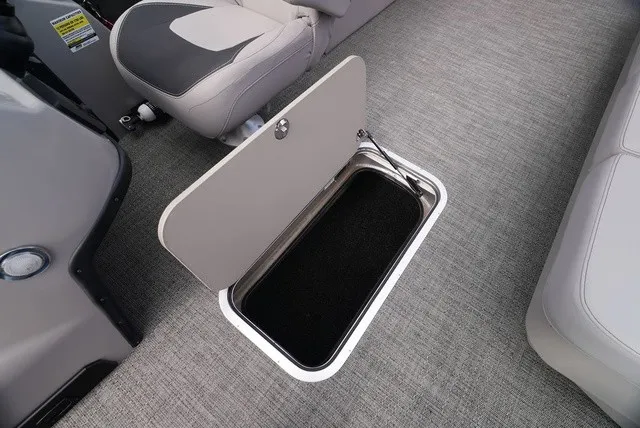 Slide: The Image of An open storage compartment on a boat with gray carpeting and cushioned seating. - 34
