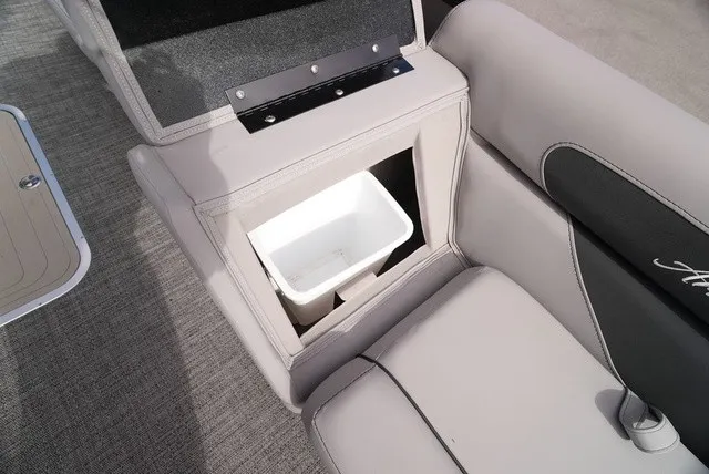 Slide: The Image of The image shows a seating area with a built-in trash bin on a Barletta Aria A22CC boat. - 37