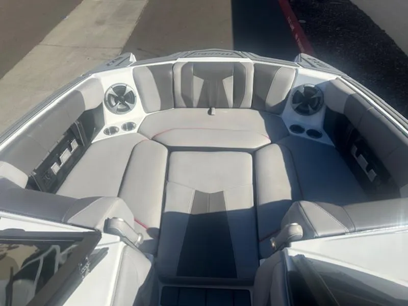 Slide: The Image of 2021 Malibu 23 MXZ boat interior with gray seating and built-in speakers. - 14