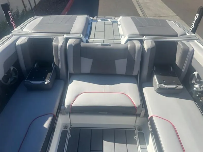 Slide: The Image of 2021 Malibu 23 MXZ boat interior with gray seating and red accents. - 18