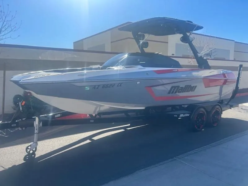 Slide: The Image of 2021 Malibu 23 MXZ boat on trailer, parked outdoors in sunlight. - 3