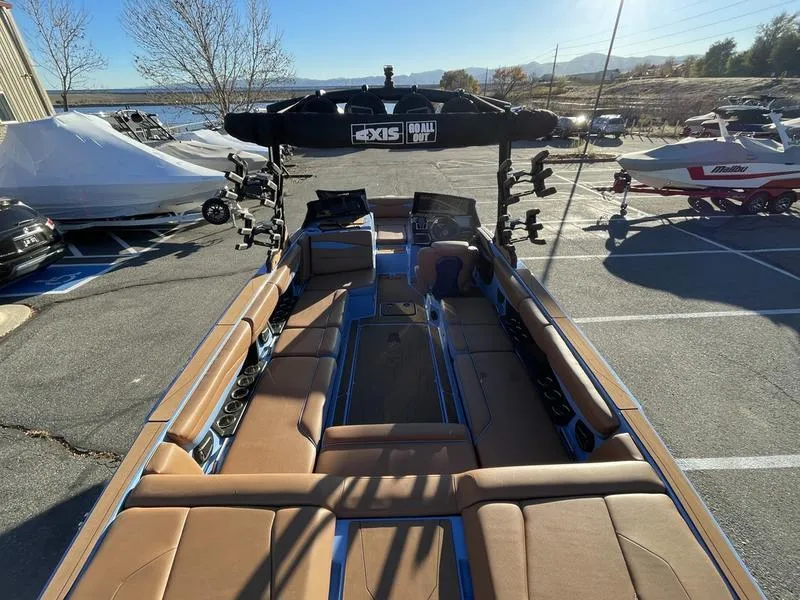 Slide: The Image of 2024 Axis A245 boat with tan seating, parked outdoors in a marina. - 4