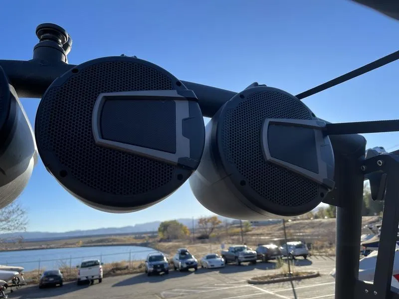 Slide: The Image of Close-up of Axis A245 boat speakers with a scenic lake and parking lot in the background. - 6