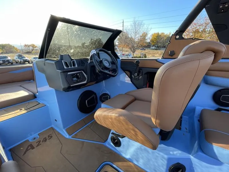 Slide: The Image of 2024 Axis A245 boat interior with brown seats and modern dashboard. - 7