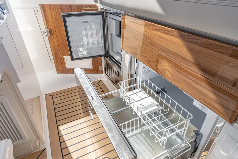 Slide: The Image of 2023 Tiara Yachts 43 LS interior with open fridge and wooden cabinetry. - 22