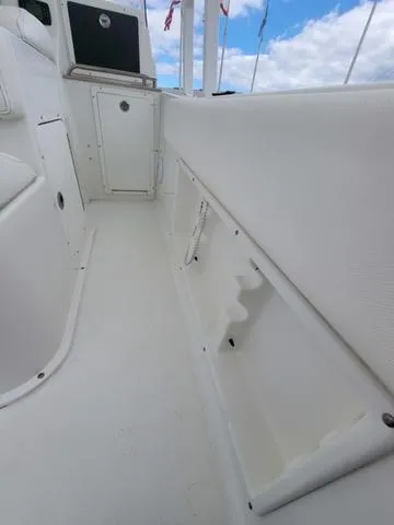 Slide: The Image of 2016 Sea Hunt Edge 24 boat interior with storage compartments and white seating. - 18