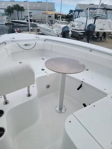 Slide: The Image of 2016 Sea Hunt Edge 24 boat interior with seating and table, docked at marina. - 24