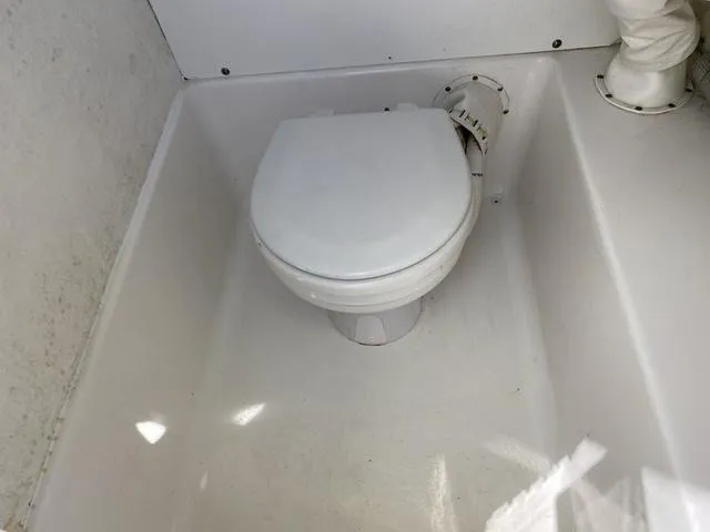 Slide: The Image of Boat toilet in a 2016 Sea Hunt Edge 24, featuring a compact, white marine design. - 42