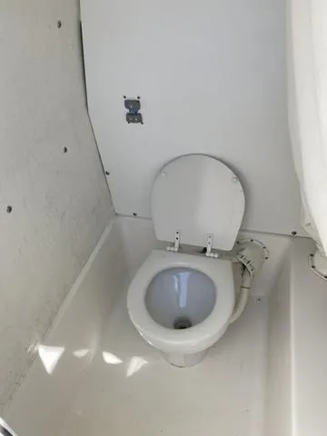 Slide: The Image of 2016 Sea Hunt Edge 24 boat interior with a compact marine toilet. - 43