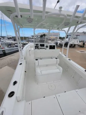 Slide: The Image of 2016 Sea Hunt Edge 24 boat with spacious deck and seating, docked at marina. - 9