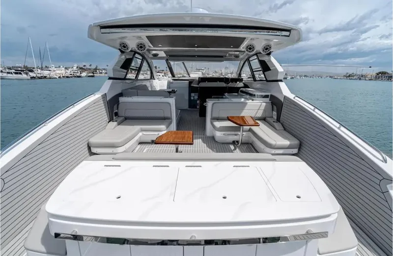 Slide: The Image of 2025 Cruisers Yachts 50 GLS luxury boat interior with seating and tables on open water. - 11