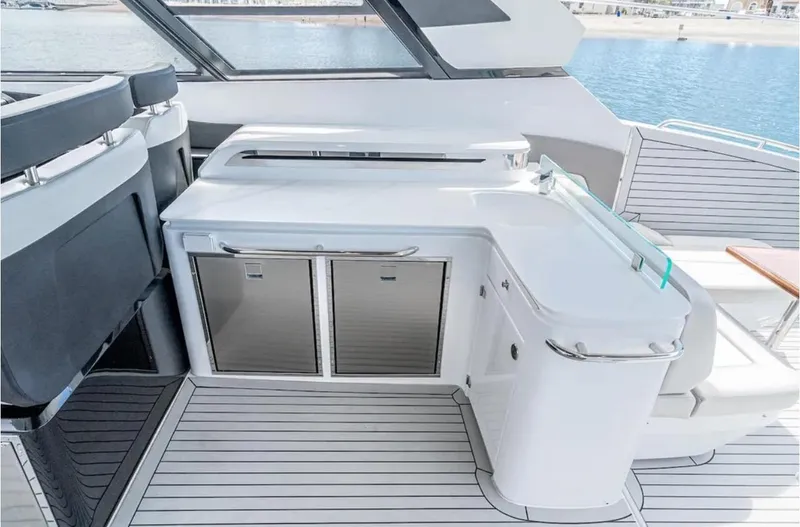 Slide: The Image of 2025 Cruisers Yachts 50 GLS deck with sleek outdoor kitchen and ocean view. - 20