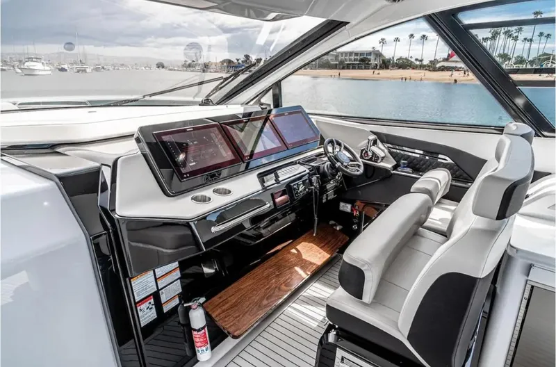 Slide: The Image of 2025 Cruisers Yachts 50 GLS helm with modern navigation displays and luxurious seating. - 25