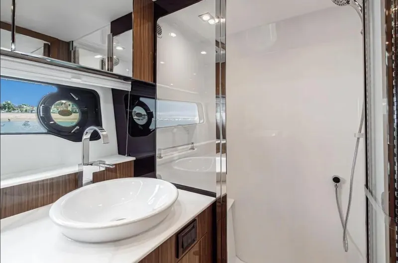 Slide: The Image of Luxurious bathroom interior of 2025 Cruisers Yachts 50 GLS with modern fixtures and porthole view. - 38