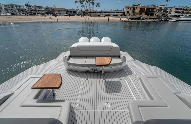 Slide: The Image of 2025 Cruisers Yachts 50 GLS luxury deck with seating, tables, and waterfront view. - 16