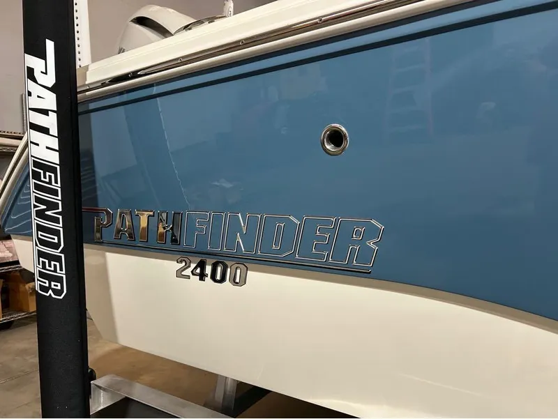 Slide: The Image of 2025 Pathfinder 2400 TRS boat, blue and white exterior, close-up view. - 4