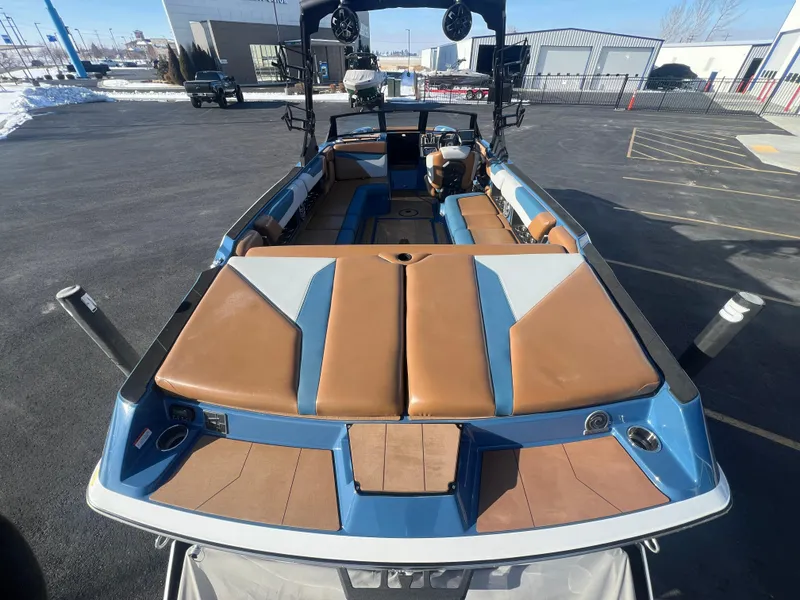 Slide: The Image of 2022 Axis Wake Research A24 boat with brown and blue interior, parked outdoors. - 10