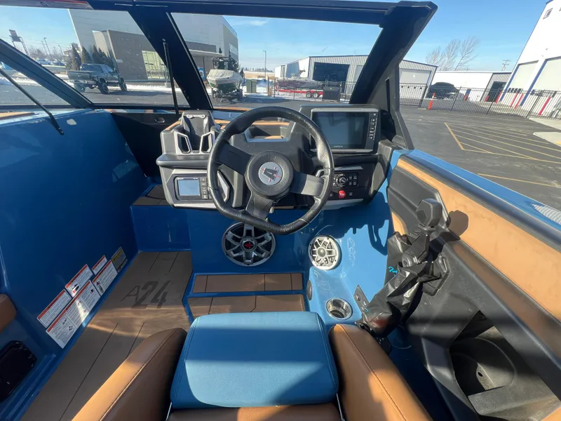 Slide: The Image of 2022 Axis Wake Research A24 boat interior with steering wheel and dashboard controls. - 17