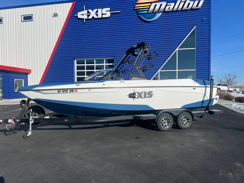 Slide: The Image of 2022 Axis Wake Research A24 boat on trailer outside dealership. - 2