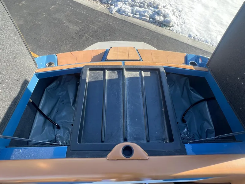 Slide: The Image of 2022 Axis Wake Research A24 boat storage compartments, open view, with snow in the background. - 23