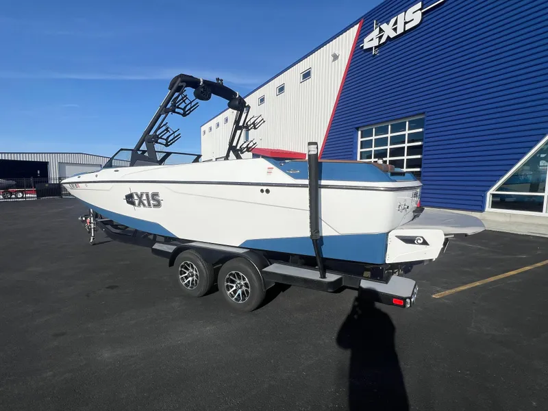 Slide: The Image of 2022 Axis Wake Research A24 boat on trailer outside dealership. - 3