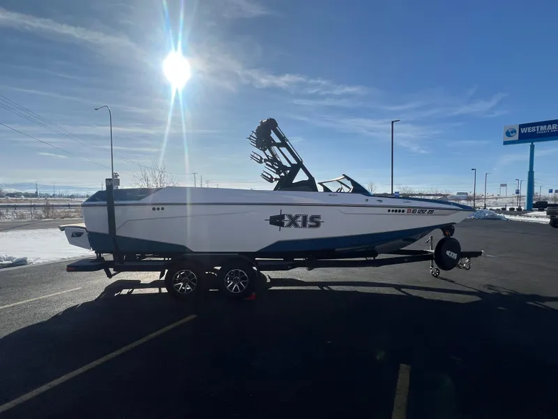 Slide: The Image of 2022 Axis Wake Research A24 boat on trailer under bright sun. - 6