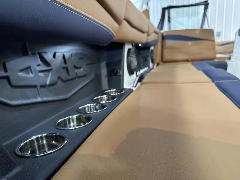 Slide: The Image of 2025 Axis A245 boat interior with tan seating and built-in cup holders. - 16