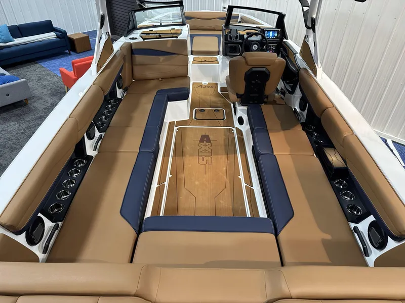 Slide: The Image of 2025 Axis A245 boat interior with tan and navy seating, modern dashboard, and spacious layout. - 6