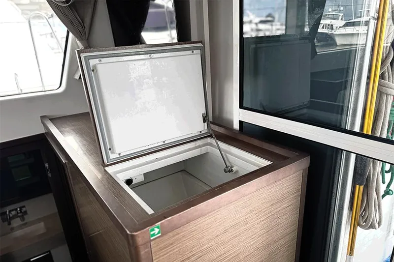 Slide: The Image of Open storage compartment inside 2019 Lagoon 40 catamaran, featuring sleek wooden finish. - 10