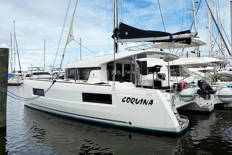Slide: The Image of 2019 Lagoon 40 catamaran docked at marina, named "Coquina." - 2