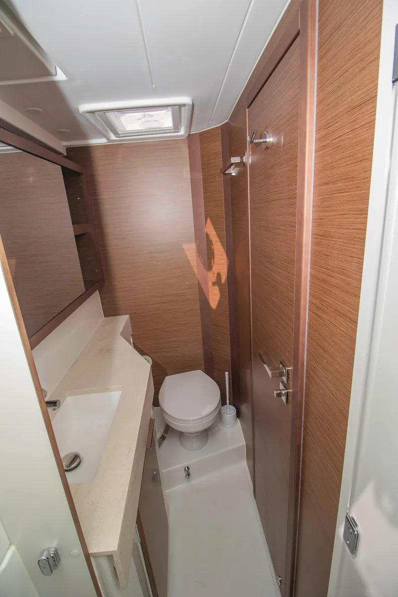 Slide: The Image of 2019 Lagoon 40 yacht bathroom with modern fixtures and wood paneling. - 27