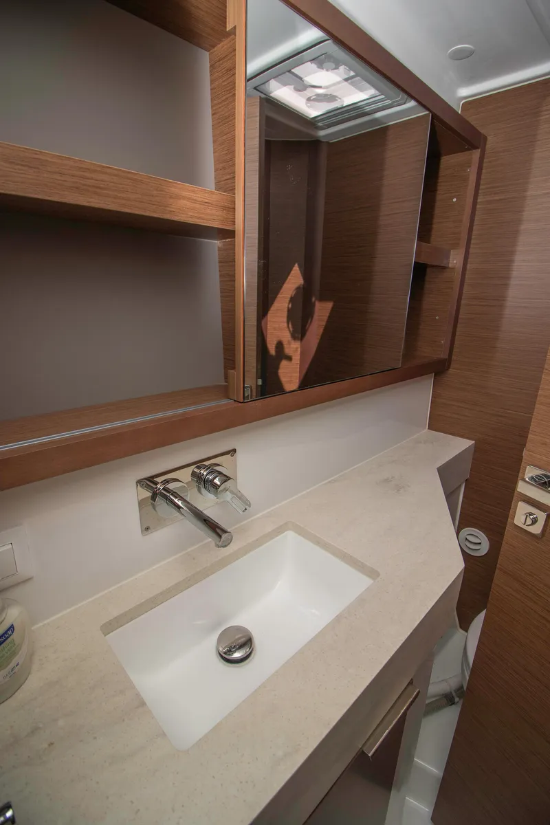 Slide: The Image of 2019 Lagoon 40 bathroom with modern sink, wooden cabinetry, and mirrored storage. - 28