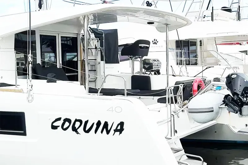 Slide: The Image of 2019 Lagoon 40 catamaran named Coquina docked at a marina. - 3