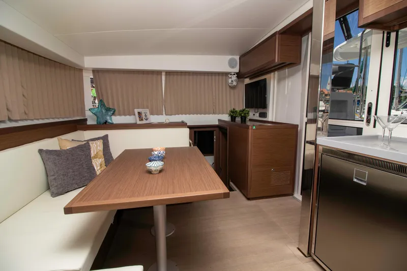 Slide: The Image of Interior of 2019 Lagoon 40 catamaran with modern dining area and wooden finishes. - 6