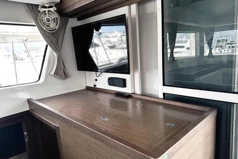 Slide: The Image of Interior of 2019 Lagoon 40 catamaran with TV and wooden cabinetry. - 7