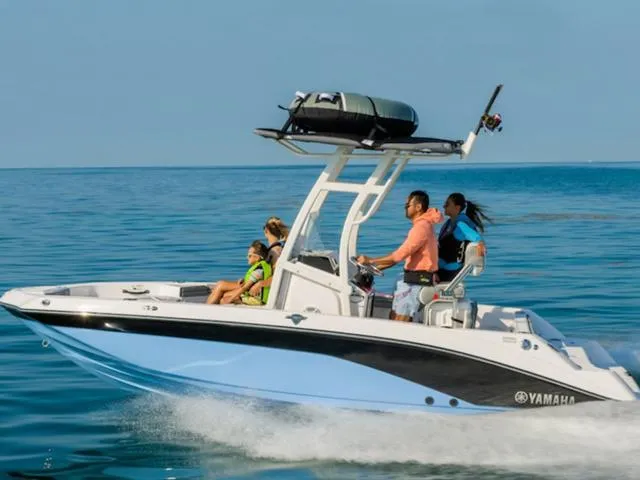 Slide: The Image of 2024 Yamaha Boats 195 FSH Sport cruising on open water with passengers. - 1