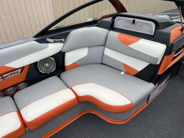 Slide: The Image of 2016 Malibu 22 VLX boat interior with orange, gray, and white seating. - 12