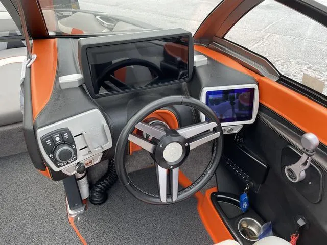 Slide: The Image of 2016 Malibu 22 VLX boat dashboard with modern controls and touchscreen displays. - 13