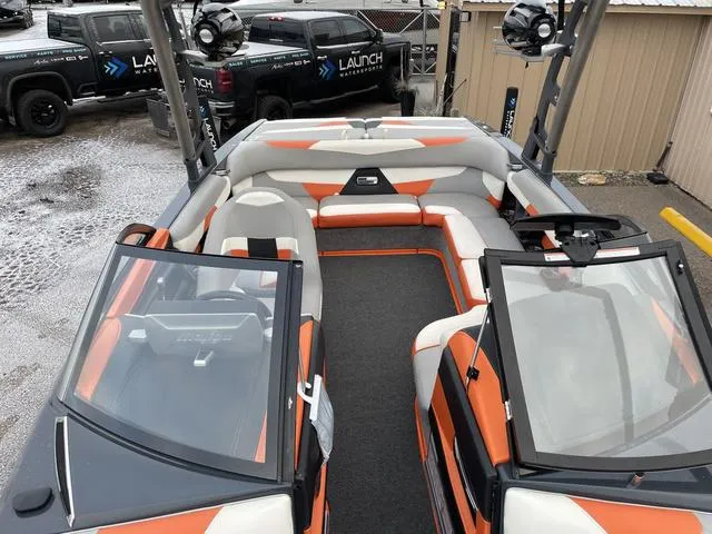Slide: The Image of 2016 Malibu 22 VLX boat interior with orange and gray seating, open bow design. - 16