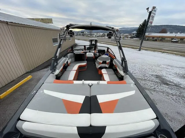 Slide: The Image of 2016 Malibu 22 VLX boat with stylish interior and wakeboard tower, parked outdoors. - 6