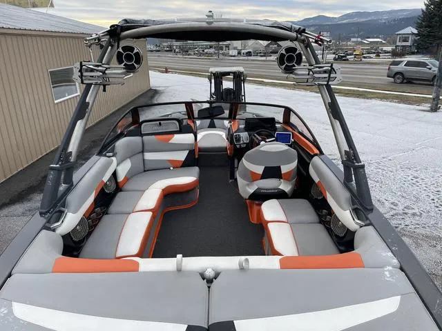 Slide: The Image of 2016 Malibu 22 VLX boat interior with orange and gray seating, speakers, and dashboard. - 8