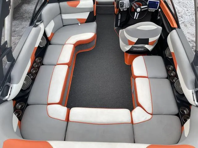 Slide: The Image of Interior of 2016 Malibu 22 VLX boat with orange and gray seating. - 9