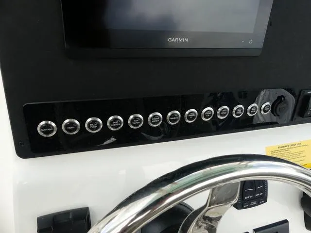 Slide: The Image of 2025 Key West 244 CC boat dashboard with Garmin display and control buttons. - 18