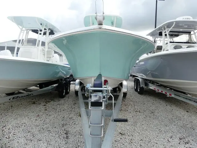 Slide: The Image of 2025 Key West 244 CC boat on trailer, flanked by two other boats. - 2