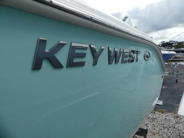Slide: The Image of 2025 Key West 244 CC boat, side view with logo, light blue hull. - 4
