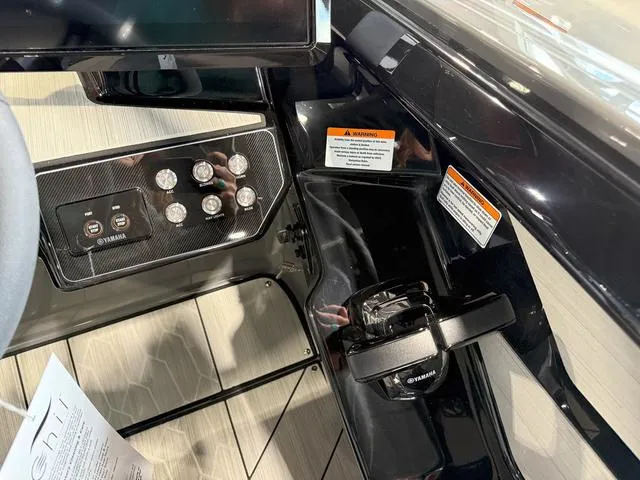 Slide: The Image of 2025 Yamaha Boats 222XE dashboard with controls and warning labels. - 12