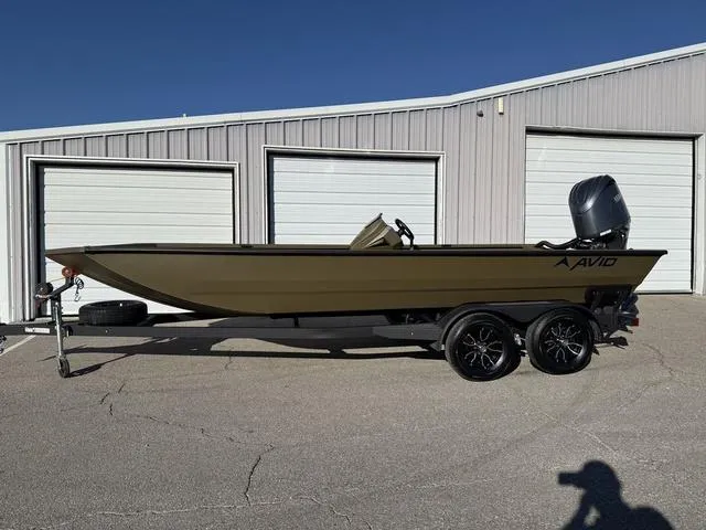 Slide: The Image of 2025 Avid 20 Rogue SC boat on trailer, parked outside storage units. - 1