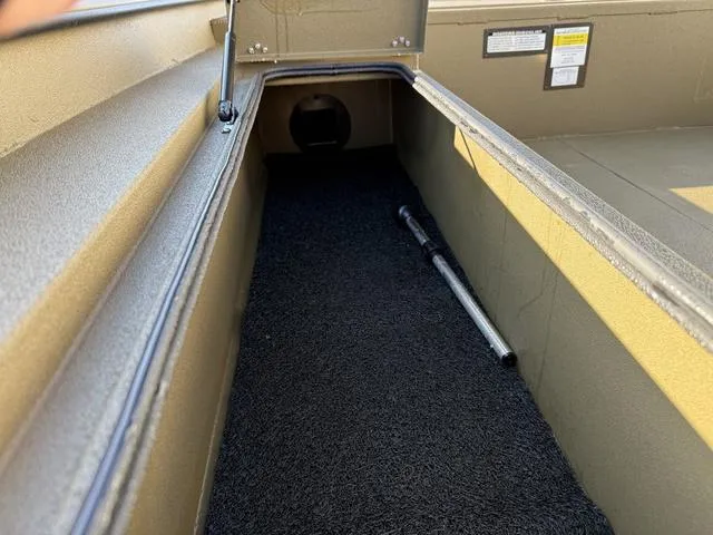 Slide: The Image of Storage compartment of 2025 Avid 20 Rogue SC boat with carpeted interior and metal rod. - 15