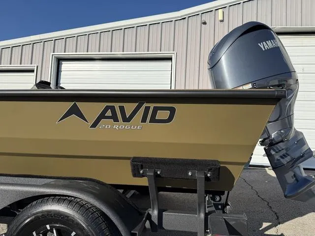 Slide: The Image of Avid 20 Rogue SC 2025 boat with Yamaha motor, parked near a garage. - 2