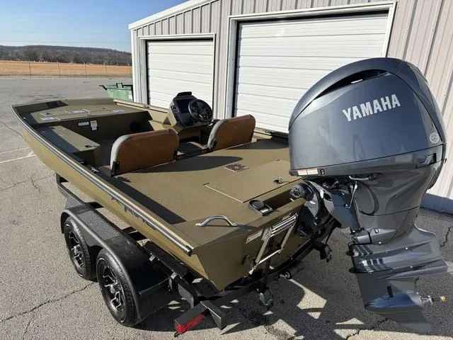 Slide: The Image of 2025 Avid 20 Rogue SC boat with Yamaha motor, parked near a garage. - 3